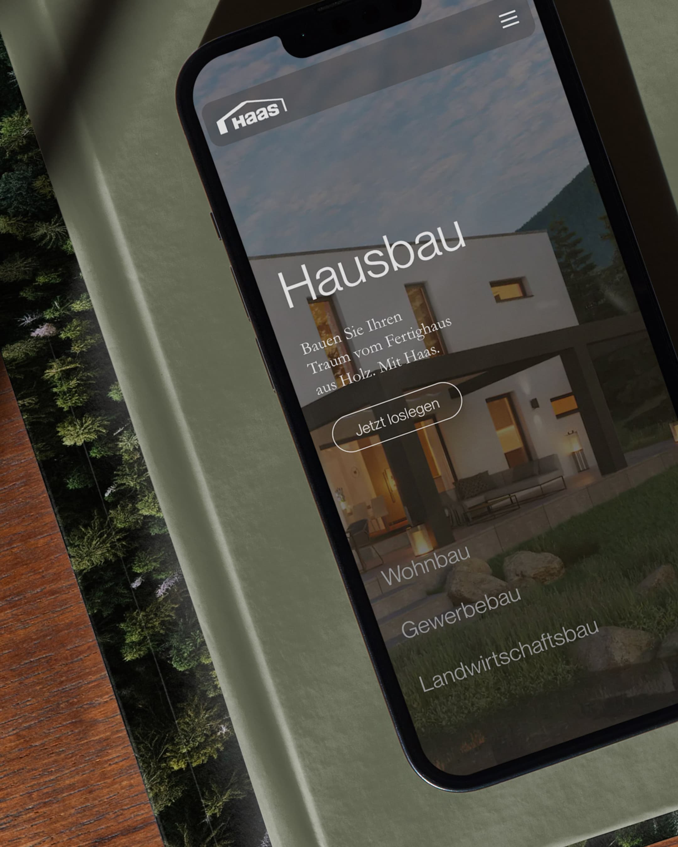 &why: Haas - Smartphone on which the intro module of the Haas Fertigbau website